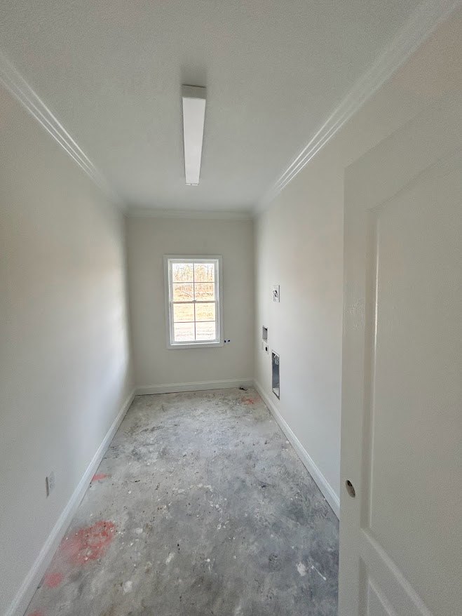Hallway with plaster walls, white door, white-framed window, and dirty flooring