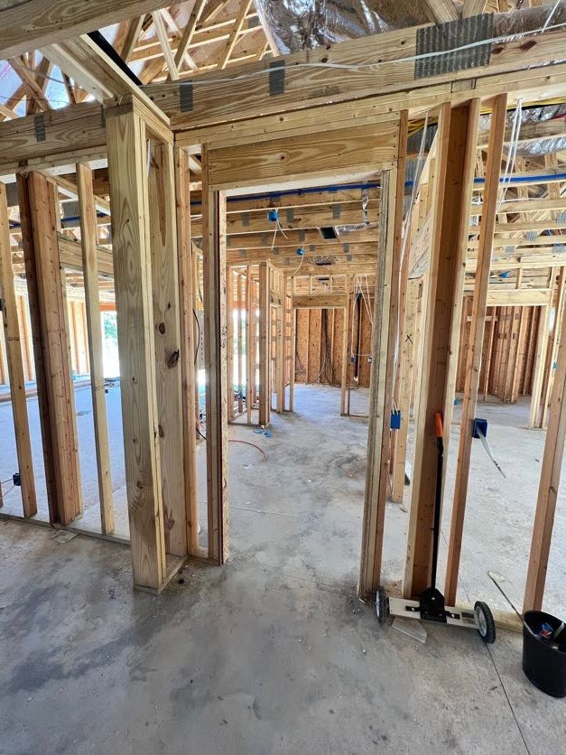 Exposed wood framing and beams with building insulation in a residential interior under construction