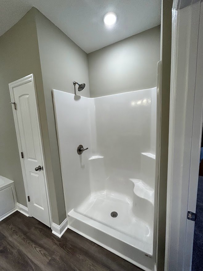 Glass-enclosed shower with chrome fixtures, white subway tile walls, and built-in niche in modern bathroom